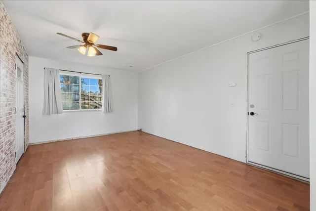 a view of an empty room with a window and a ceiling fan
