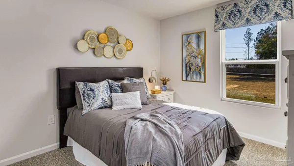 a bedroom with a bed and painting on the wall