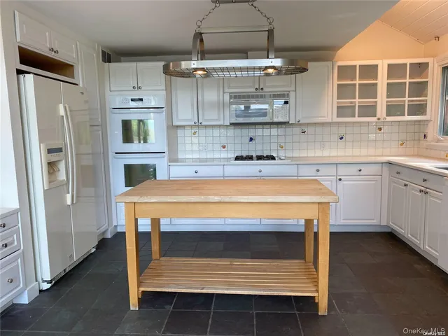 a kitchen with kitchen island a stove and a sink