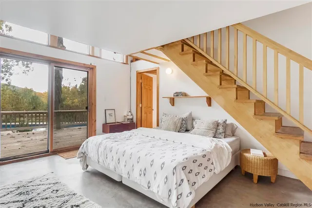 a bedroom with a bed and a large window