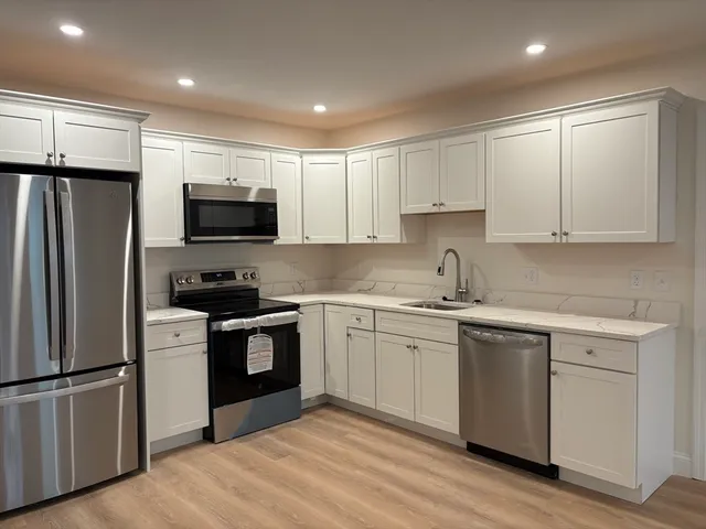 a kitchen with stainless steel appliances granite countertop a stove a sink and a refrigerator