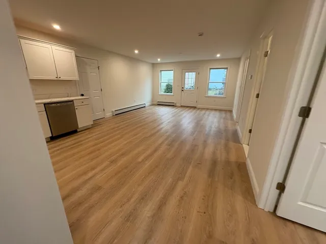 a view of a kitchen with wooden floor and electronic appliances