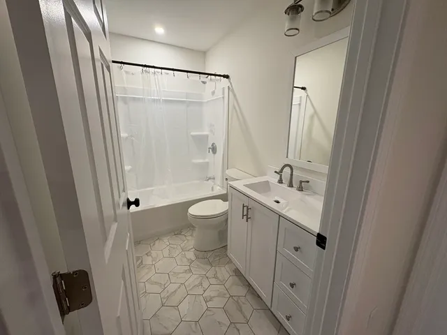 a bathroom with a double vanity sink toilet mirror and shower