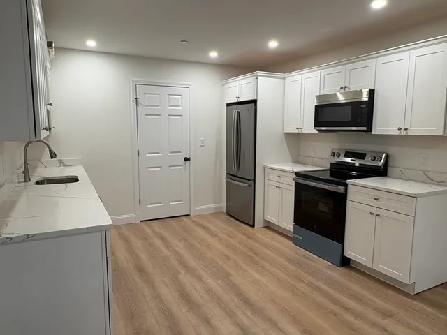 a kitchen with a sink appliances and cabinets
