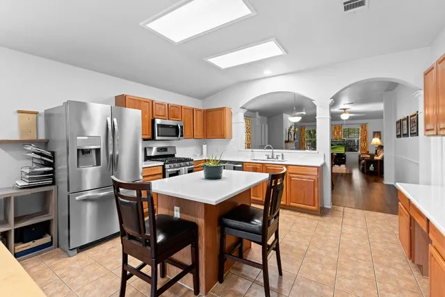 a kitchen with stainless steel appliances a dining table and chairs