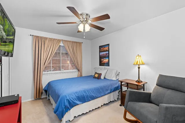 a bedroom with bed couch and window