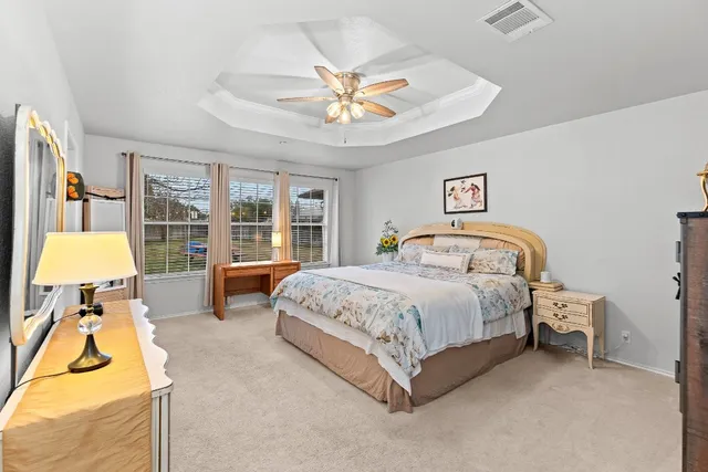 a spacious bedroom with a bed and a chandelier