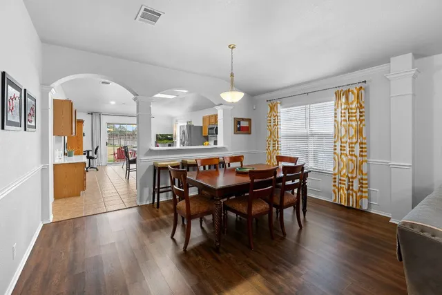 a view of a a dining room with furniture window and wooden floor