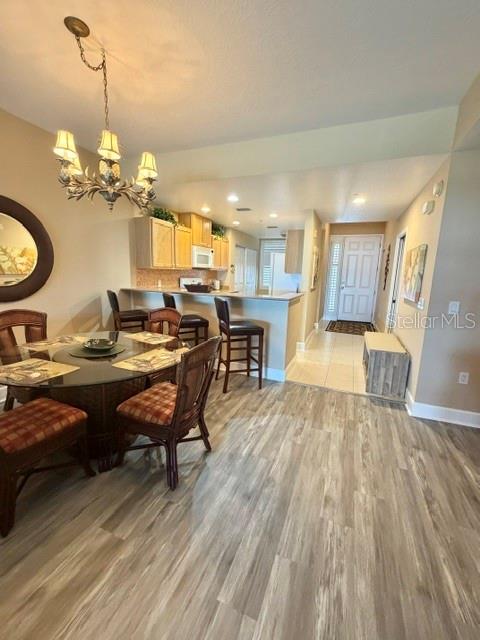13413 Gasparilla Road, Unit 304 Placida, FL 33946 - Photo 9 of 28 a view of a dining room and livingroom with furniture wooden floor a rug a flat screen tv a painting and a chandelier