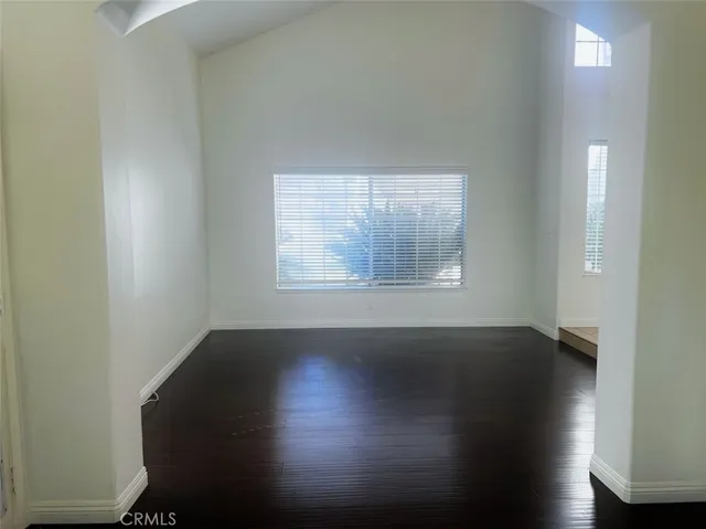 a view of a hallway with wooden floor and a bathroom