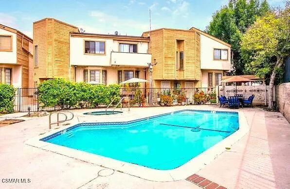 a view of a swimming pool with outdoor seating and a tree