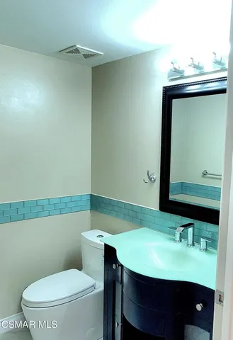 a bathroom with a toilet a sink and mirror