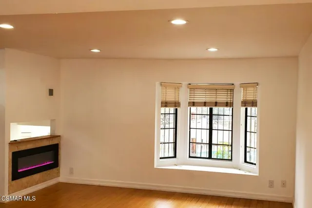 a view of an empty room with a window and fire place