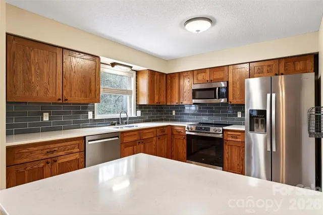 a kitchen with stainless steel appliances granite countertop a refrigerator stove and sink