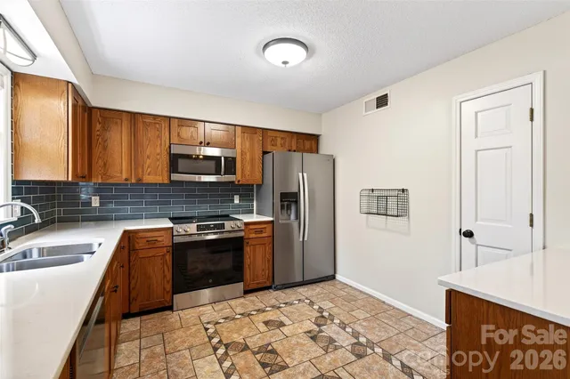 a kitchen with stainless steel appliances granite countertop a sink a stove a microwave a sink and cabinets