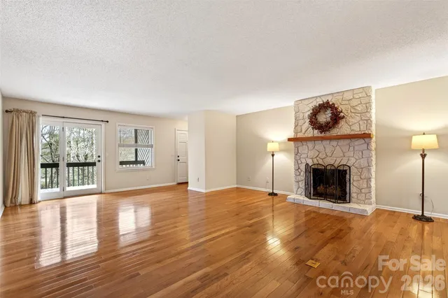 a view of an empty room with window and wooden floor