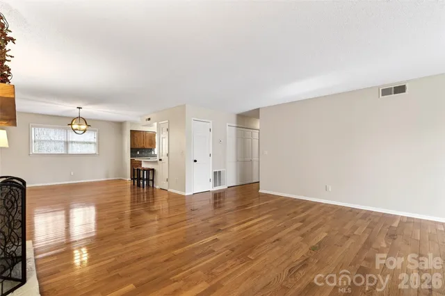 a view of a room with wooden floor staircase and a chandelier