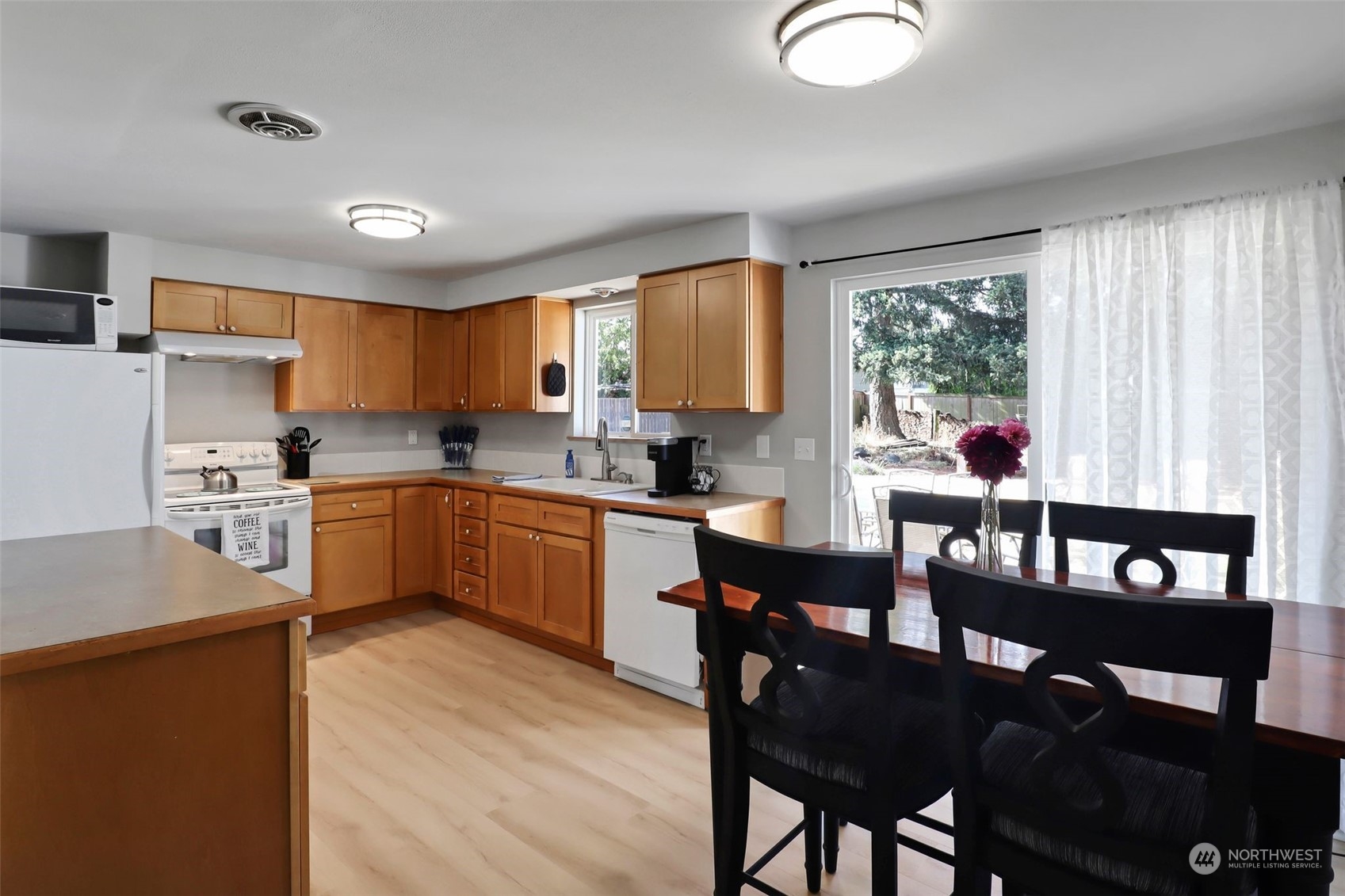 11504 Southeast 178th Place Renton, WA 98055 - Photo 17 of 30 a kitchen with a dining table chairs and refrigerator