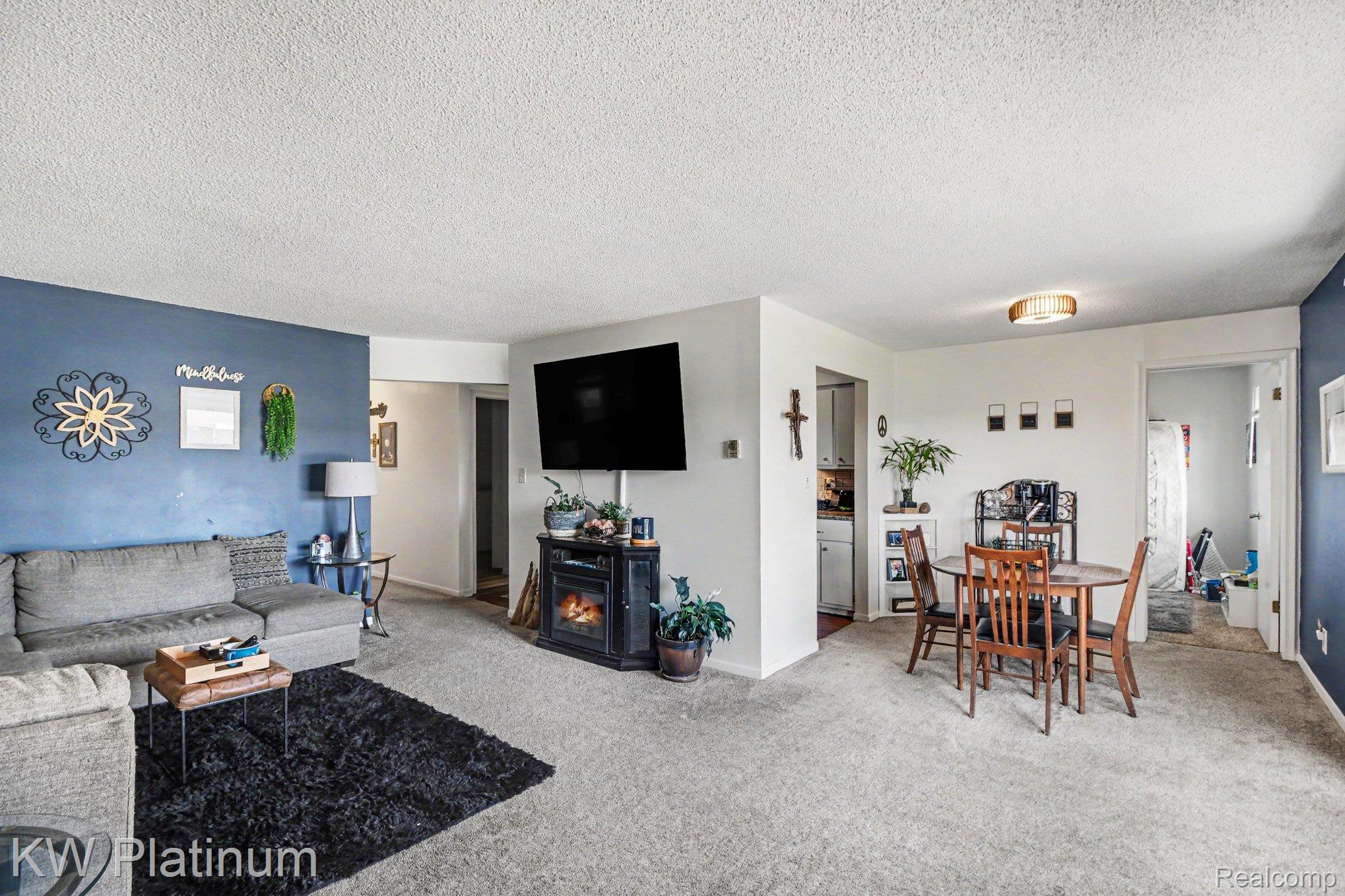 1900 River Road, Unit C5 Marysville, MI 48040 - Photo 7 of 15 Living area with light carpet, a textured ceiling, and a fireplace