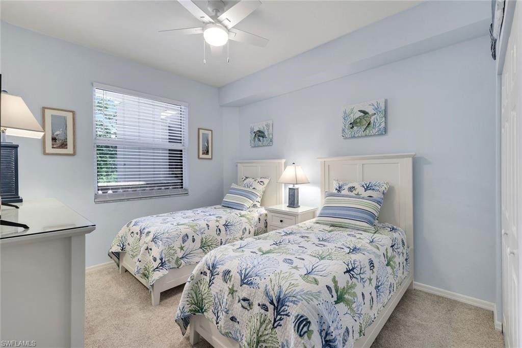 460 Launch Circle, Unit 202 Naples, FL 34108 - Photo 17 of 34 a bedroom with two beds and a window