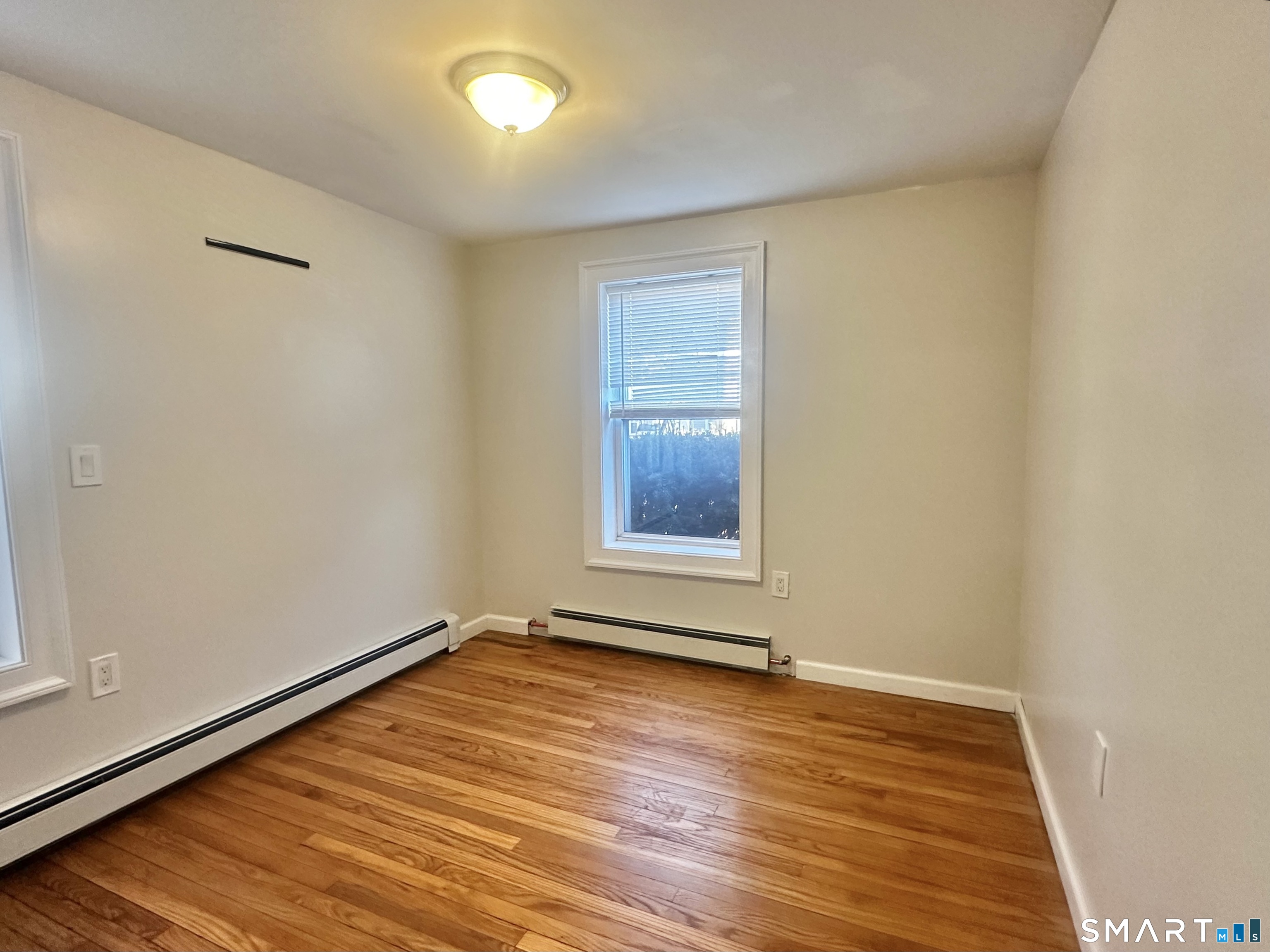 49 Pleasant Street Ansonia, CT 06401 - Photo 13 of 17 a view of an empty room with wooden floor and a window
