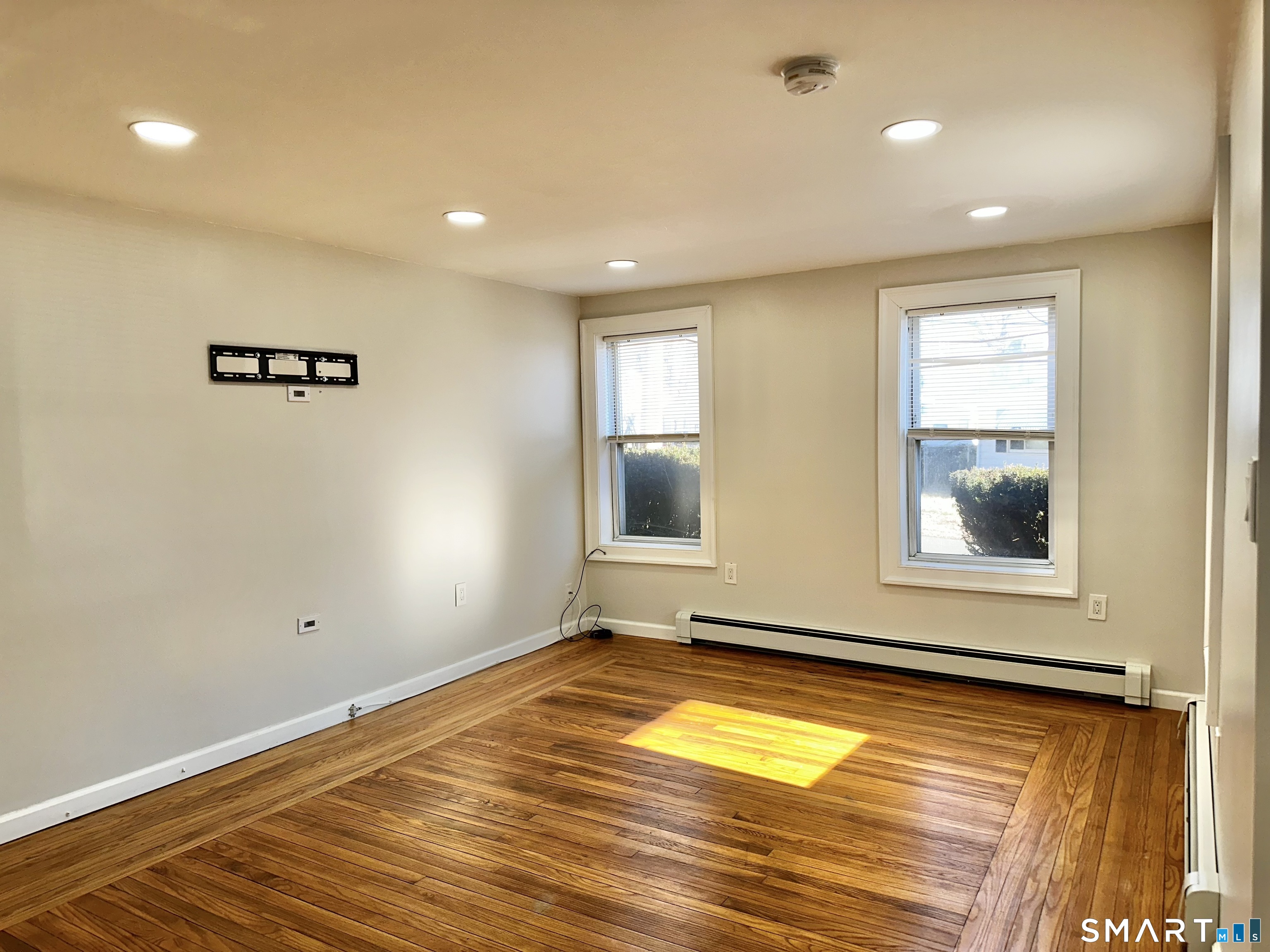 49 Pleasant Street Ansonia, CT 06401 - Photo 7 of 17 a view of empty room with window and wooden floor