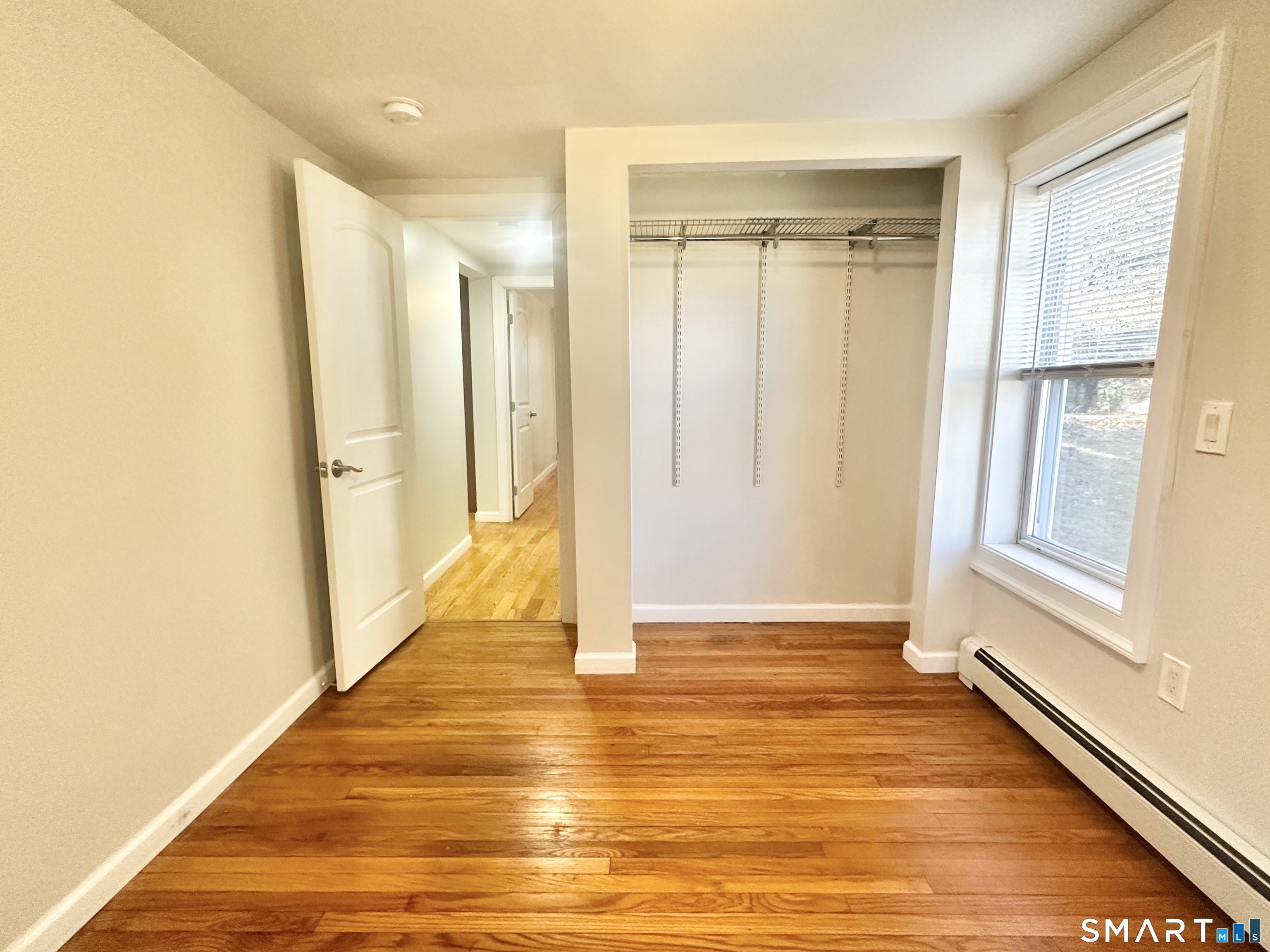 49 Pleasant Street Ansonia, CT 06401 - Photo 8 of 17 a view of a hallway with wooden floor and a bathroom