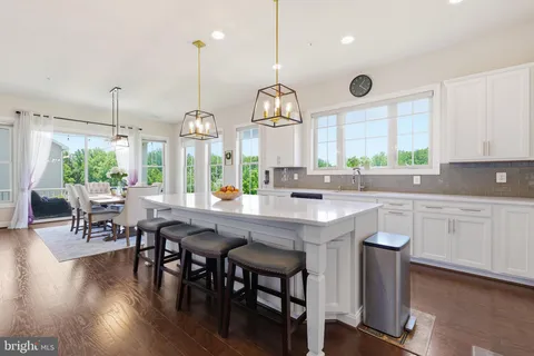 a view of a dining room and livingroom with furniture wooden floor a rug a chandelier