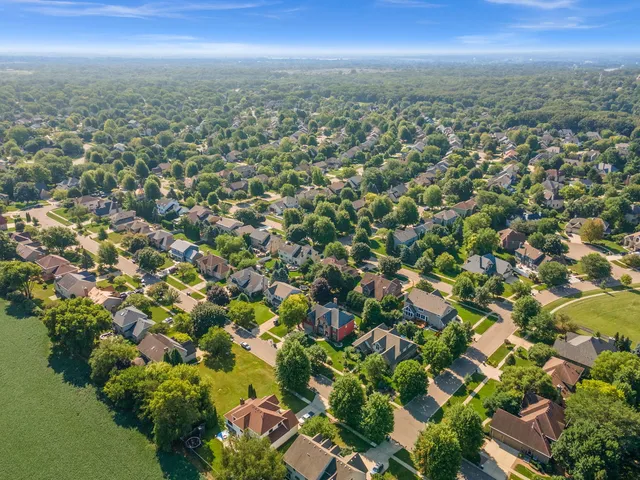 an aerial view of residential houses with city and green space