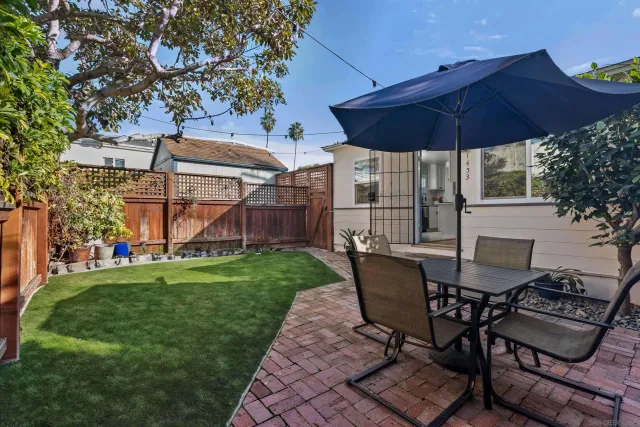 a patio with a table and chairs under an umbrella