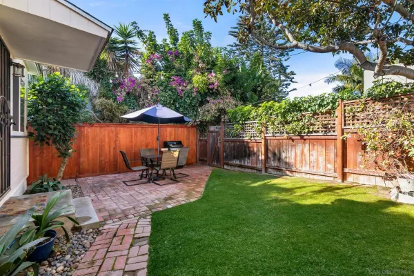 a backyard of a house with table and chairs