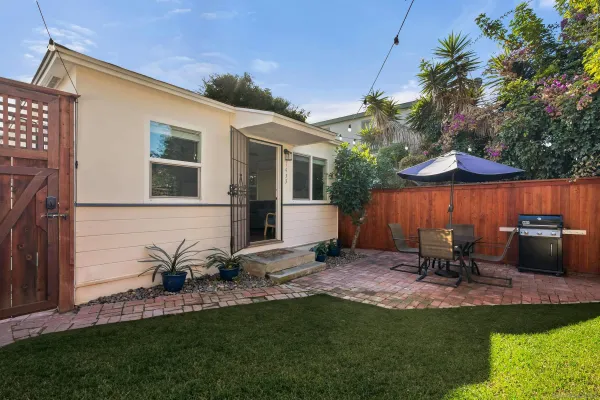 a view of a chair and table in backyard of the house