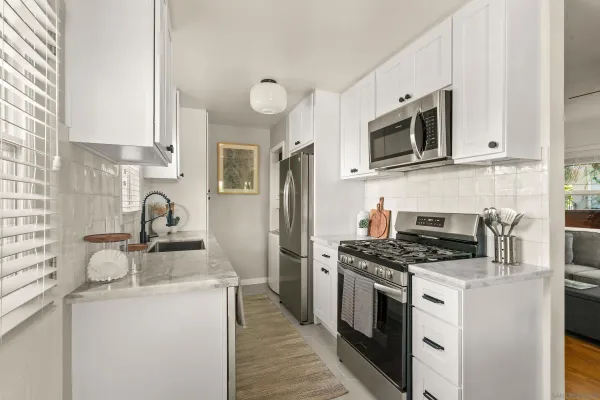 a kitchen with stainless steel appliances granite countertop a sink stove microwave and refrigerator