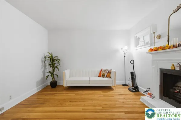 a view of empty room with fireplace and wooden floor