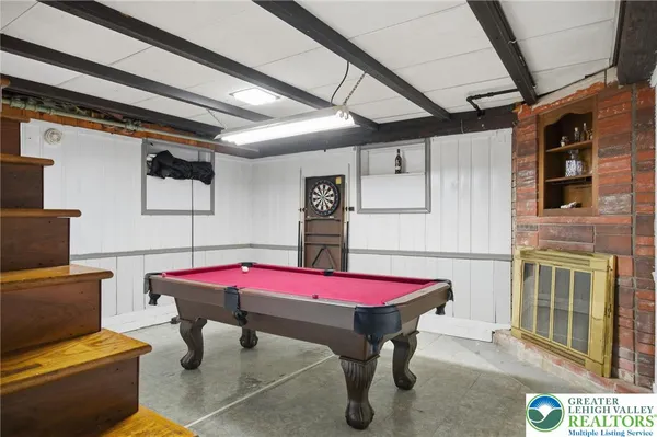 a room with pool table and windows