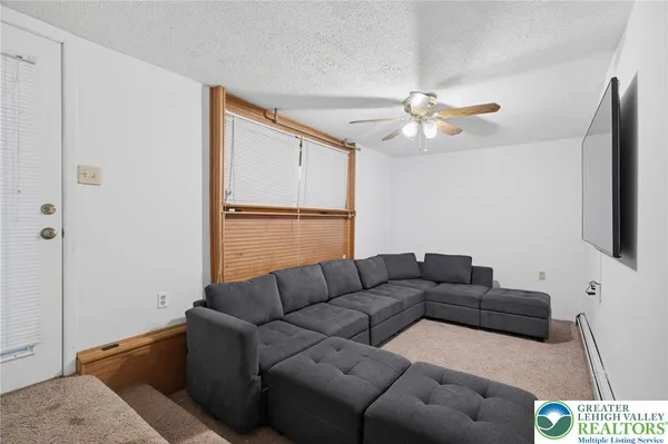 a living room with furniture a ceiling fan and a rug