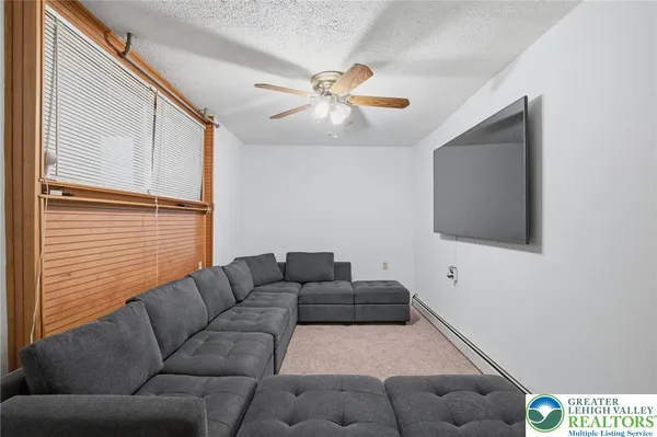 a living room with furniture and a ceiling fan