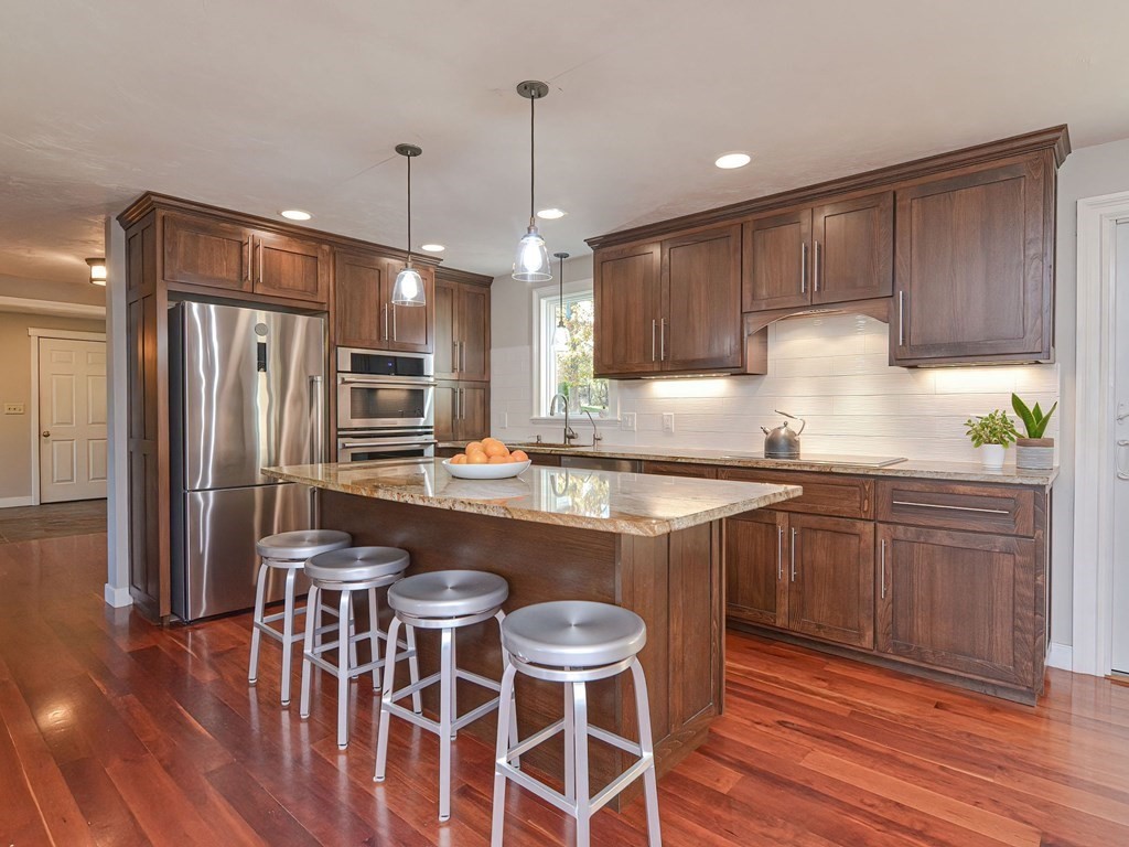 89 McClellan Road Sutton, MA 01590 - Photo 16 of 42 a kitchen with granite countertop a table chairs stove a sink and dishwasher