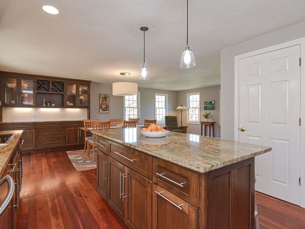 89 McClellan Road Sutton, MA 01590 - Photo 17 of 42 a kitchen with a stove a sink a center island and wooden floor
