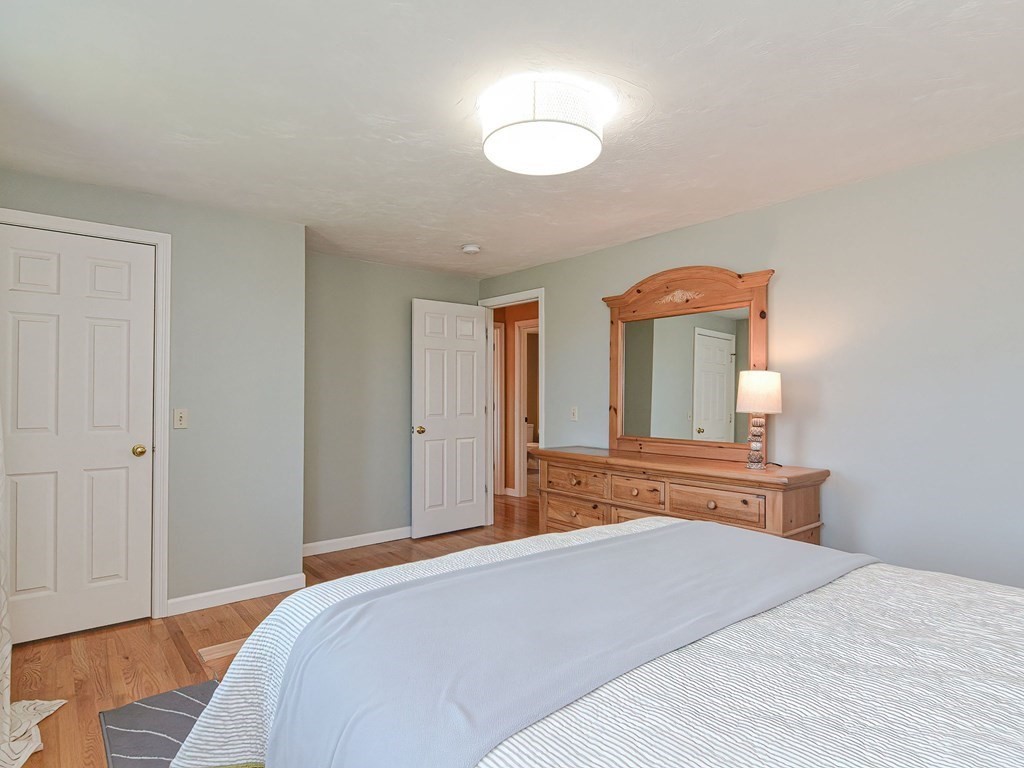 89 McClellan Road Sutton, MA 01590 - Photo 29 of 42 a bedroom with a bed and a chandelier