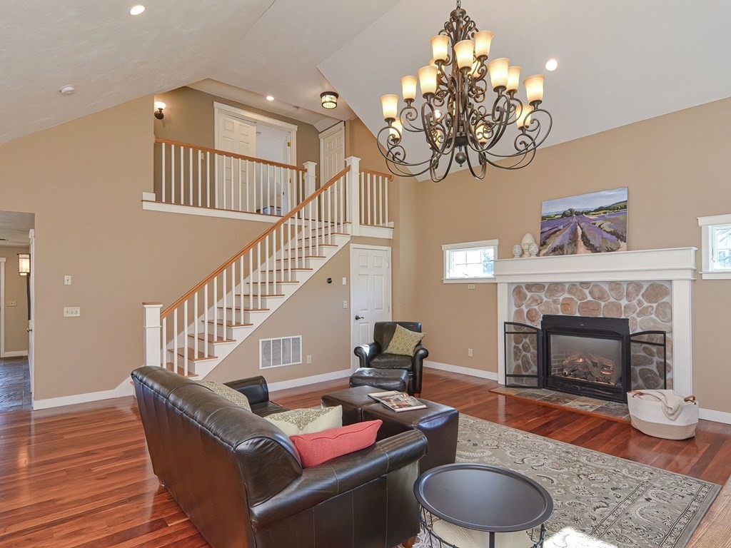 89 McClellan Road Sutton, MA 01590 - Photo 7 of 42 a living room with furniture a chandelier and a fireplace
