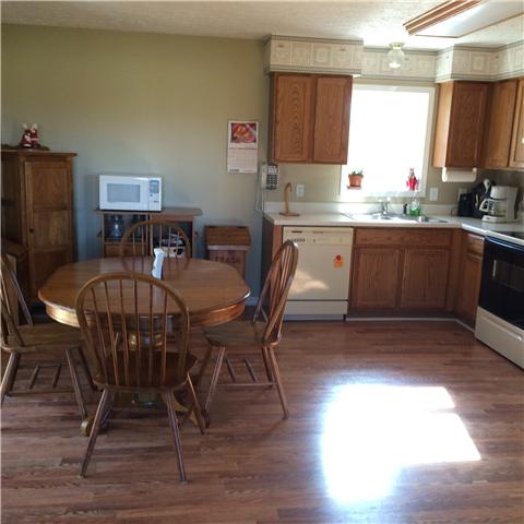 5729 Hopewell Road Springfield, TN 37172 - Photo 3 of 12 a kitchen with granite countertop a dining table chairs and a wooden floor