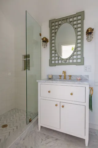 a bathroom with a sink mirror vanity and a shower