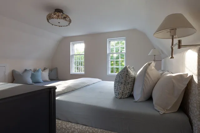 a bed room with a bed a mirror and a chandelier