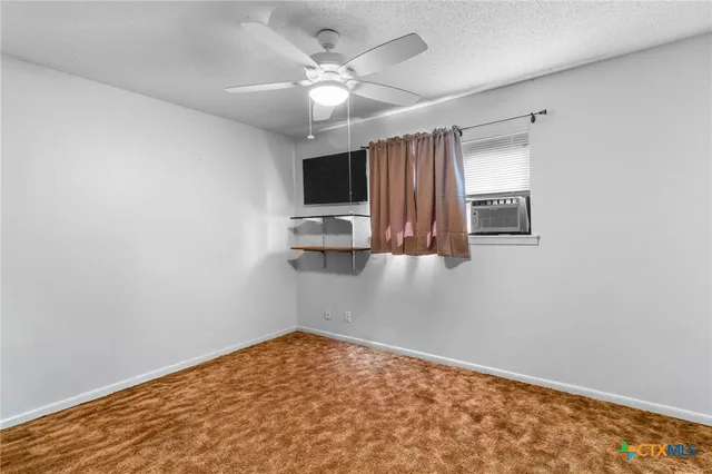 a view of kitchen and empty room with wooden floor