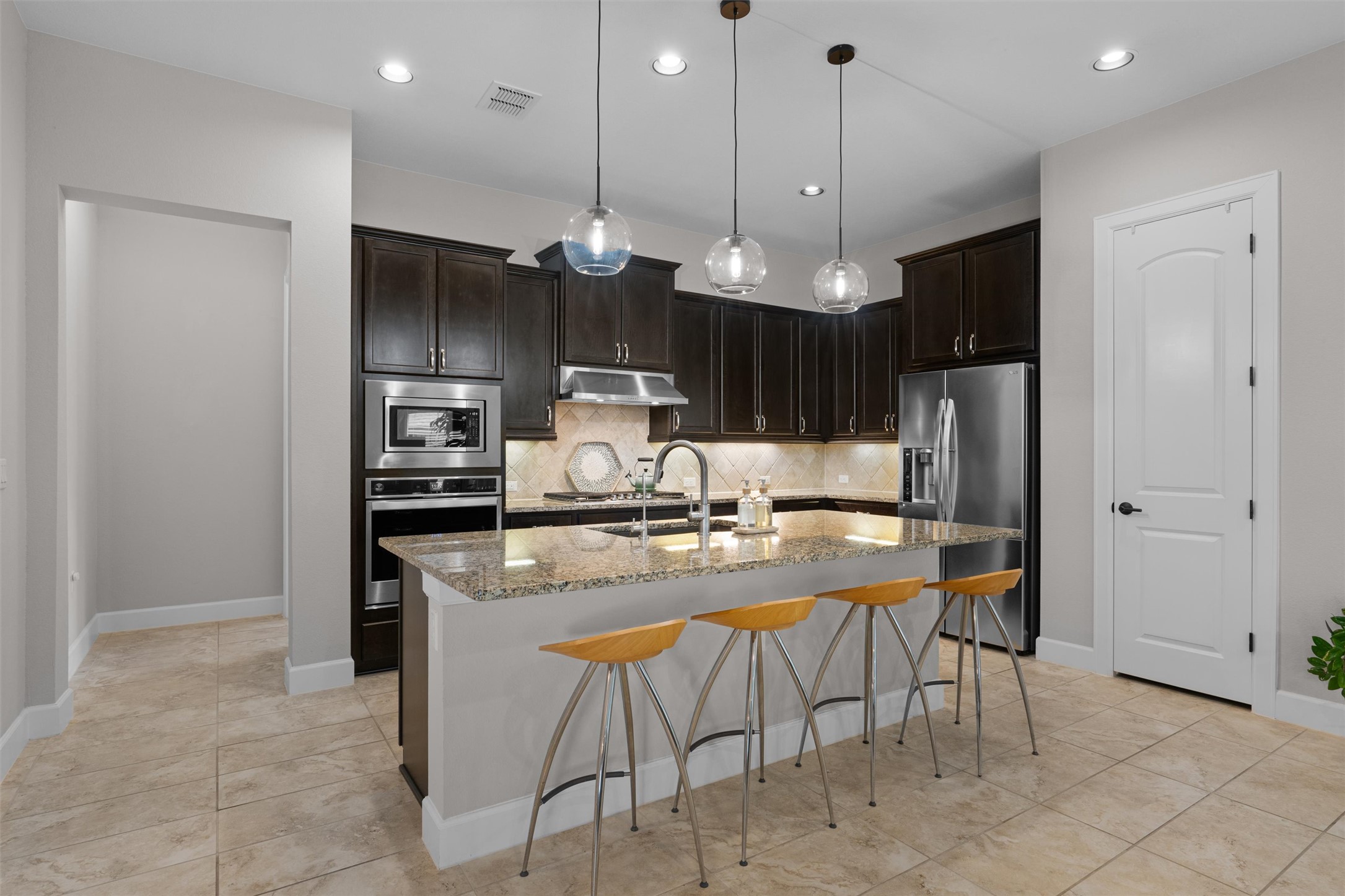 313 Racing Oak Loop San Marcos, TX 78666 - Photo 13 of 39 a kitchen with refrigerator and chairs