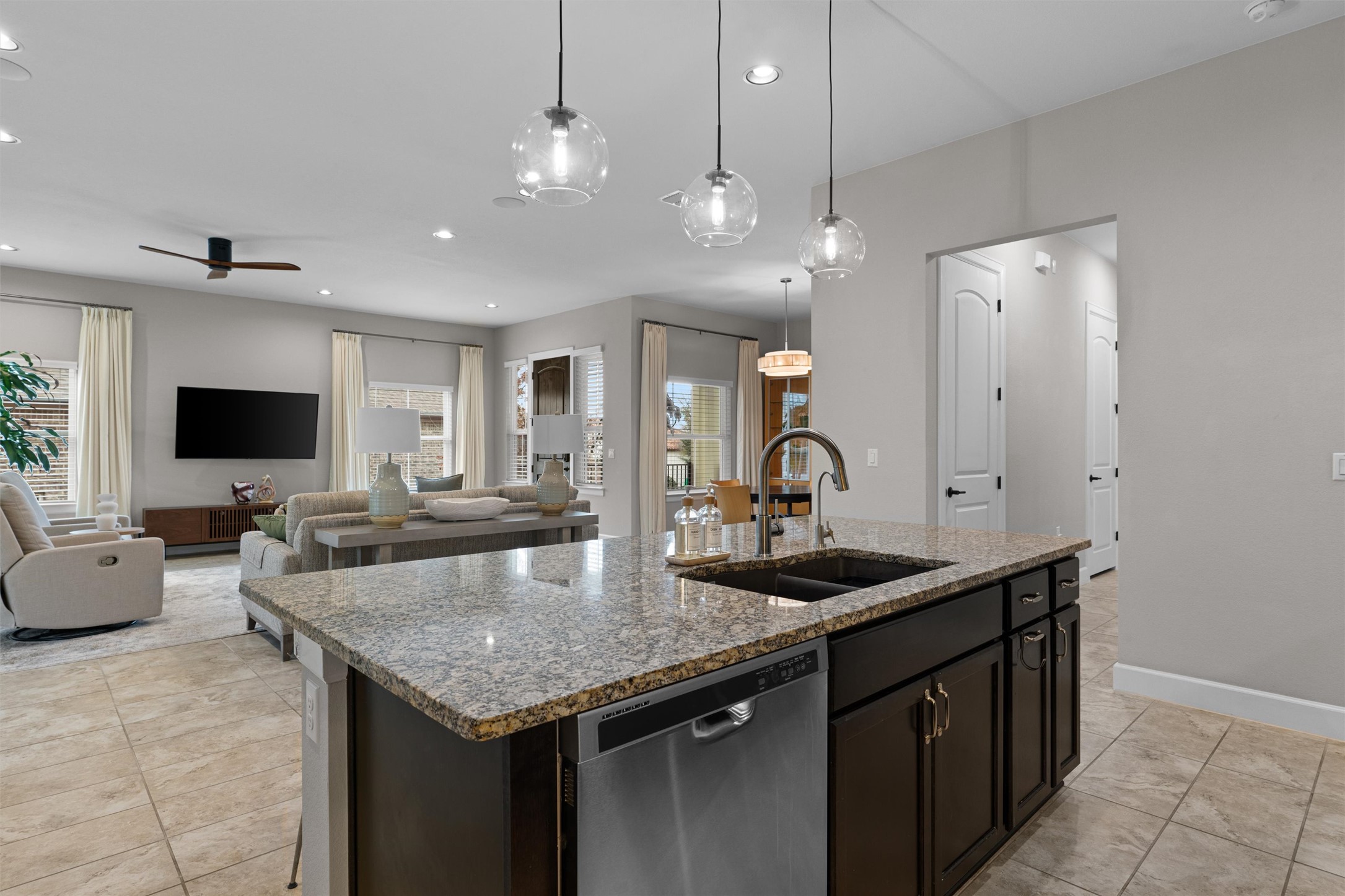 313 Racing Oak Loop San Marcos, TX 78666 - Photo 14 of 39 a kitchen with granite countertop a sink a counter top space and living room view