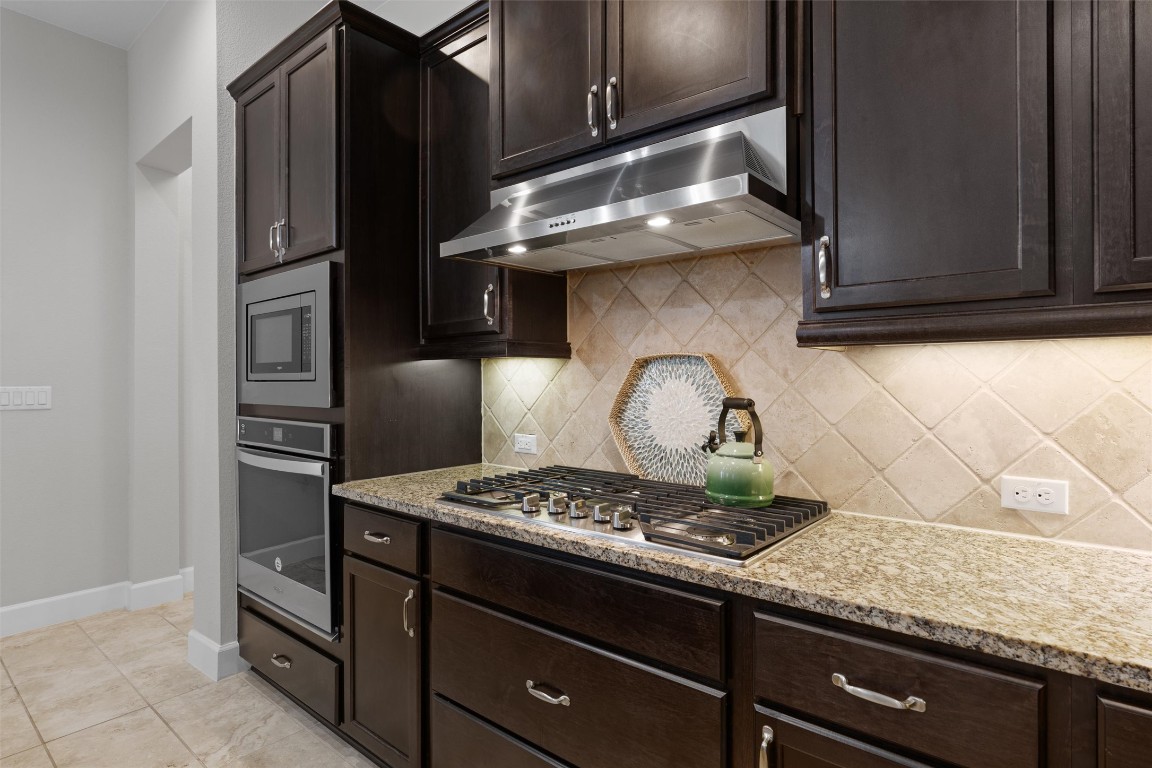 313 Racing Oak Loop San Marcos, TX 78666 - Photo 15 of 39 Under-cabinet lighting shows off the tile backsplash, stainless appliances and granite countertops.
