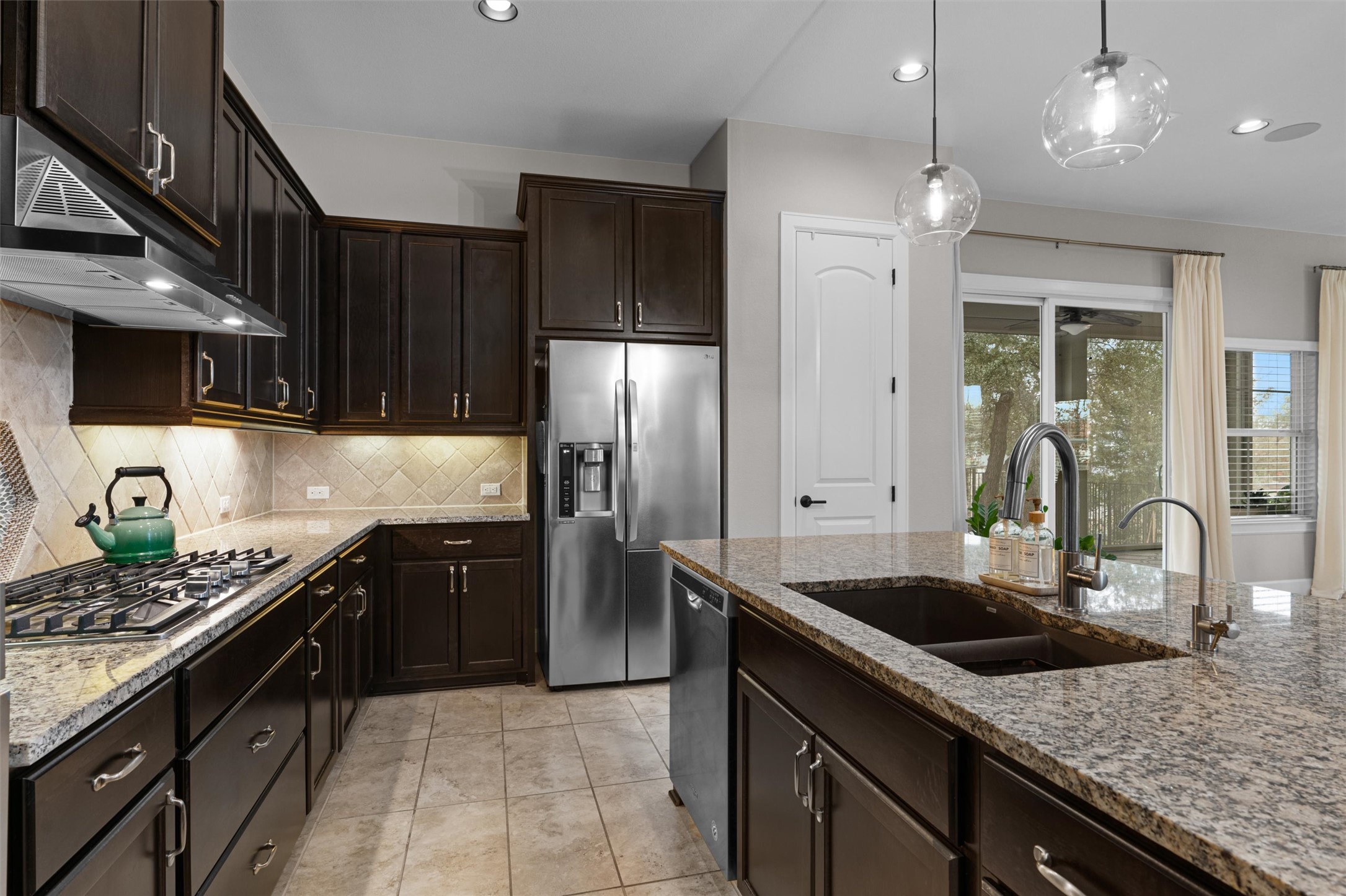 313 Racing Oak Loop San Marcos, TX 78666 - Photo 16 of 39 a kitchen with stainless steel appliances granite countertop a sink a stove and a refrigerator