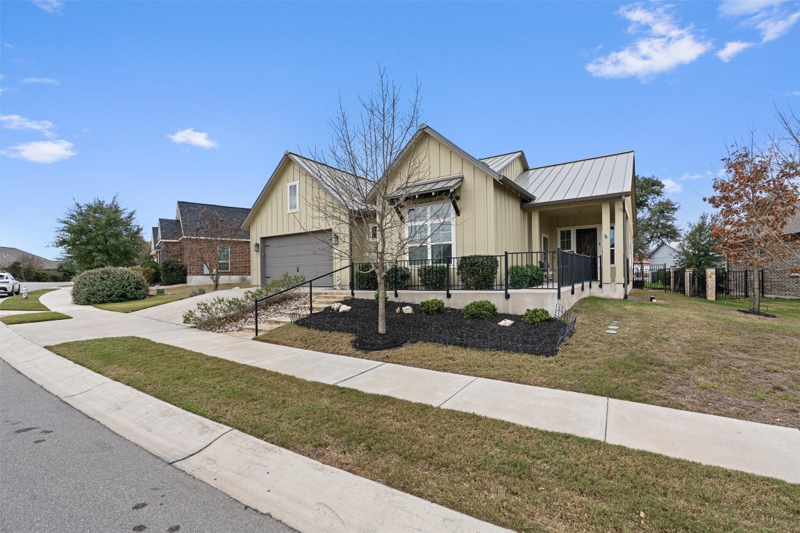 313 Racing Oak Loop San Marcos, TX 78666 - Photo 2 of 39 Another front view with the elevated lot, covered front porch with iron railings and landscaping